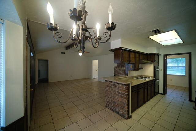 kitchen featuring an inviting chandelier, dark brown cabinets, white gas stovetop, light tile floors, and kitchen peninsula