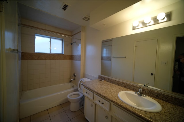 full bathroom with oversized vanity, toilet, tile floors, and tiled shower / bath