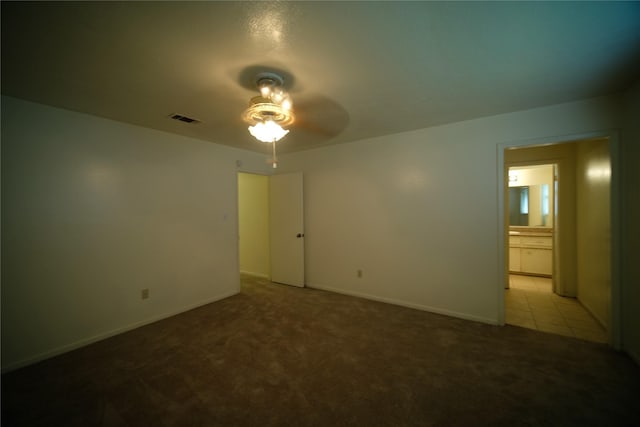 spare room with ceiling fan and light colored carpet