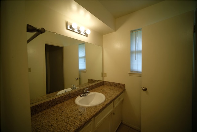 bathroom featuring plenty of natural light and vanity with extensive cabinet space