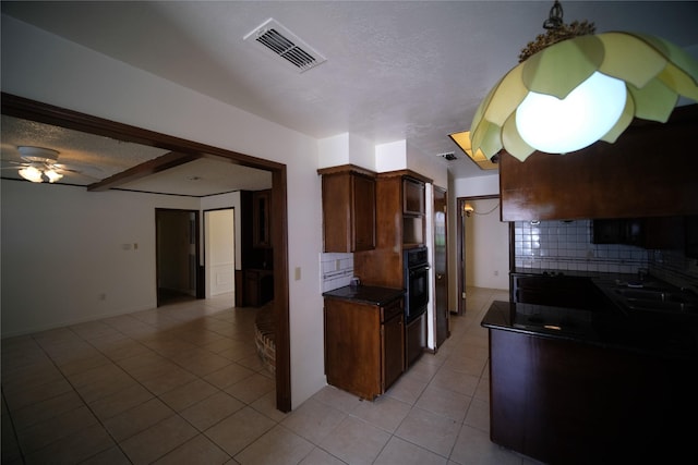 kitchen featuring ceiling fan, sink, light tile floors, black oven, and tasteful backsplash