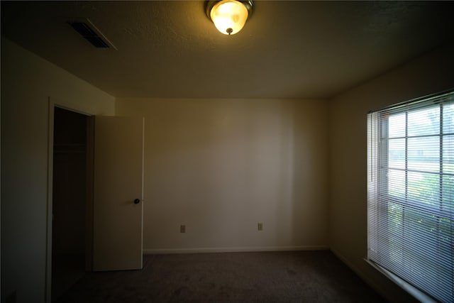 spare room featuring dark carpet