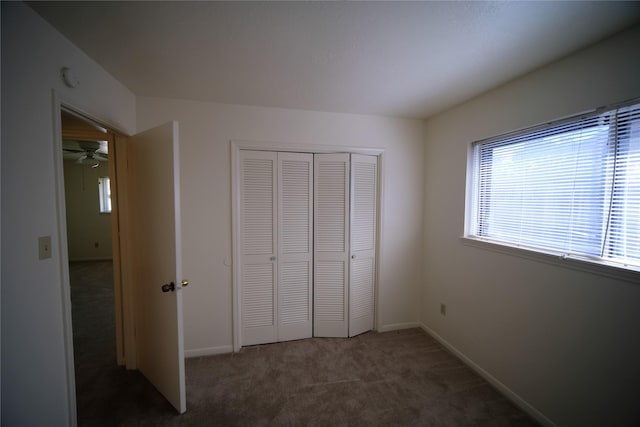 unfurnished bedroom with a closet and dark carpet