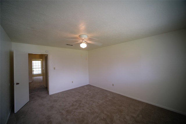 carpeted spare room with a textured ceiling and ceiling fan