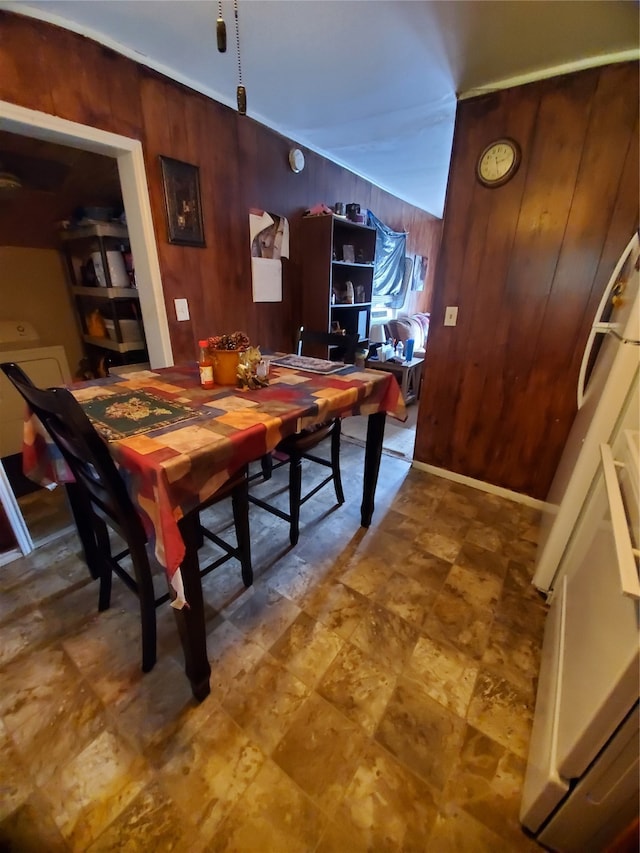 dining area with tile floors and wood walls