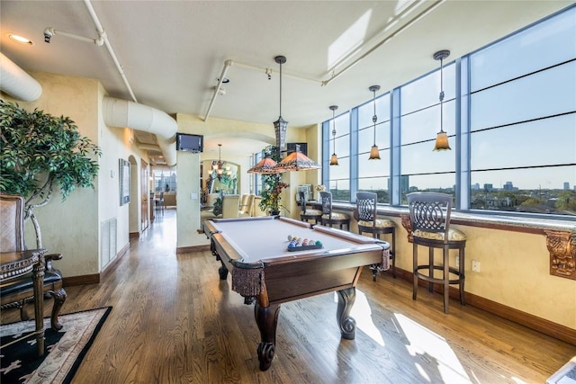 playroom with track lighting, hardwood / wood-style floors, pool table, and indoor bar