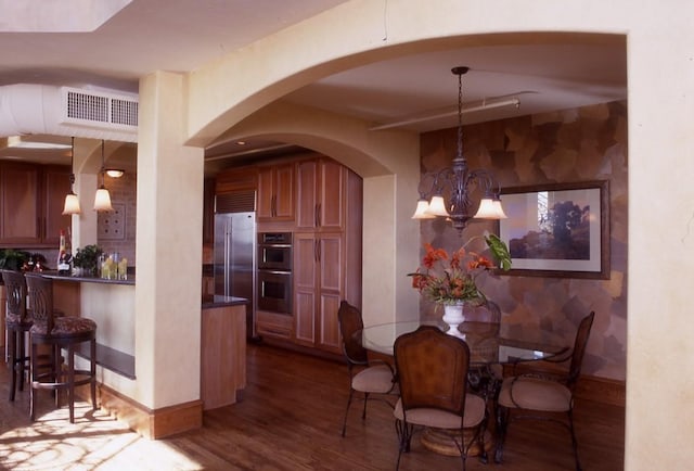 dining space with a chandelier and dark hardwood / wood-style flooring