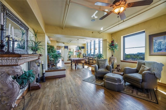 living room featuring ceiling fan, a fireplace, and wood-type flooring