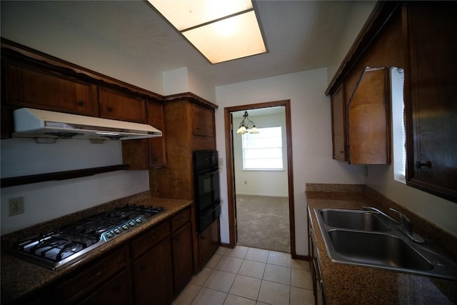 kitchen with stainless steel gas stovetop, an inviting chandelier, sink, light tile floors, and dark brown cabinets