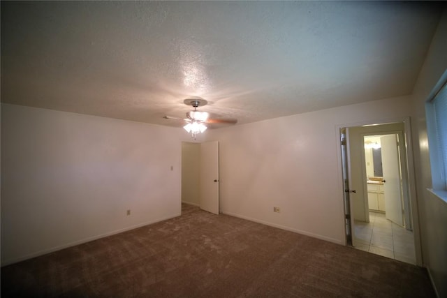 carpeted spare room with ceiling fan and a textured ceiling