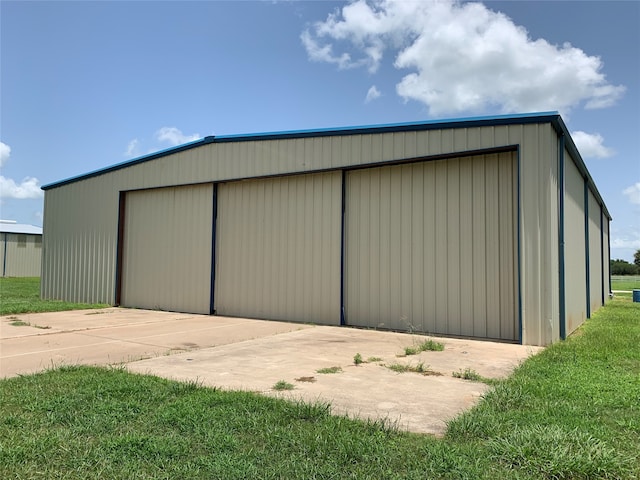 view of shed / structure with a garage and a yard