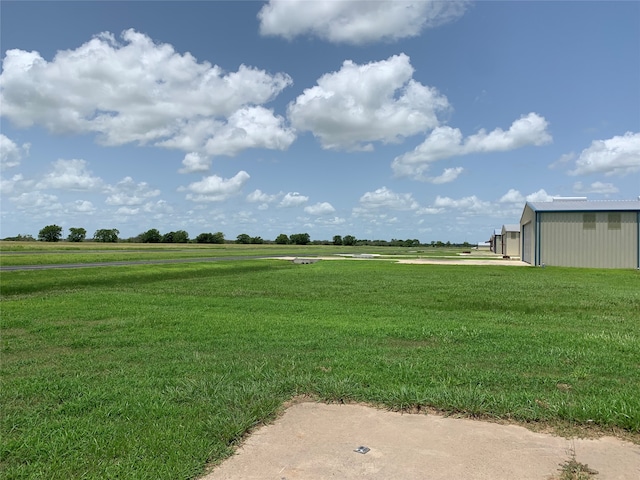 view of yard with an outdoor structure and a rural view