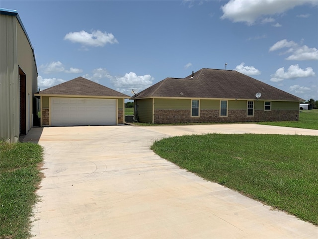 single story home with a front yard, an outdoor structure, and a garage