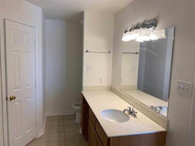 bathroom featuring tile floors, toilet, and large vanity