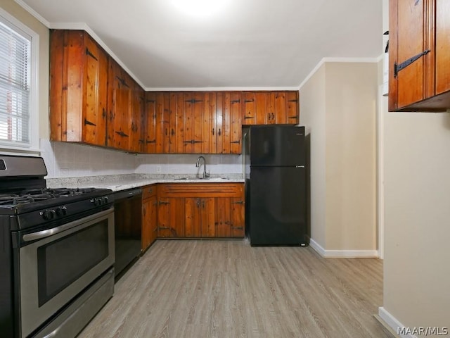 kitchen featuring ornamental molding, light hardwood / wood-style floors, black appliances, and sink