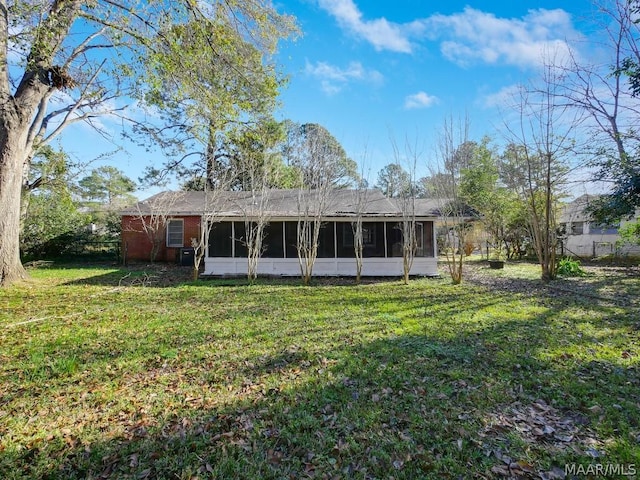 rear view of property with a yard and a sunroom