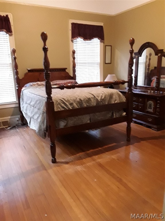 bedroom featuring crown molding and wood-type flooring