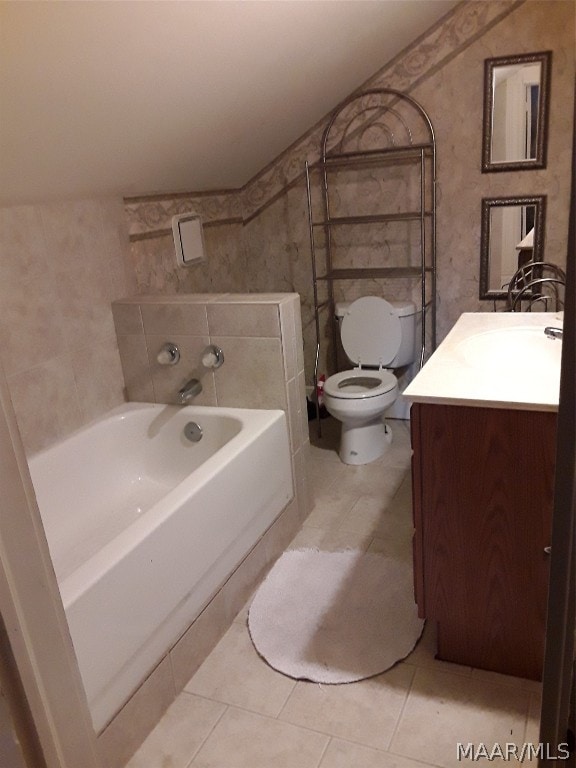 bathroom featuring tile flooring, a bathtub, toilet, and vanity