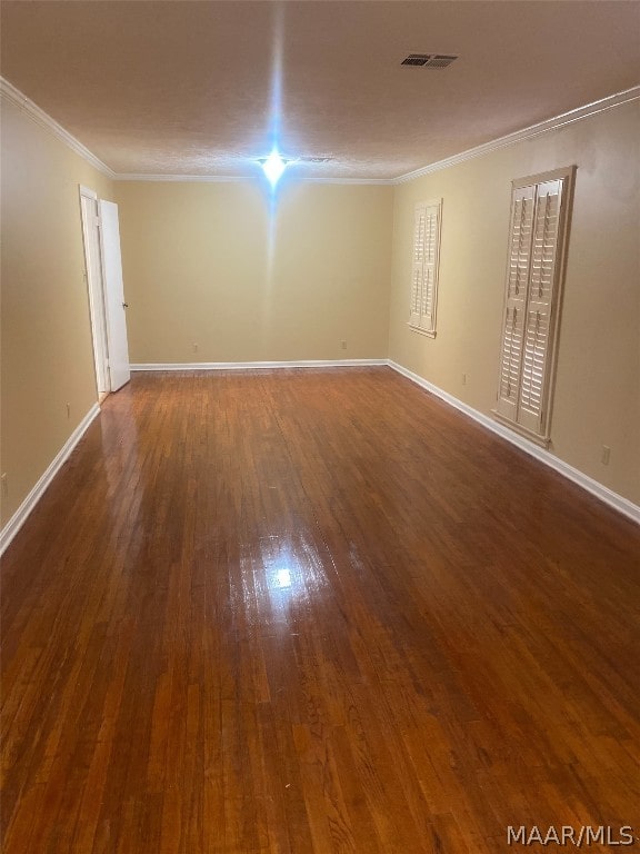 unfurnished room featuring ornamental molding and dark wood-type flooring