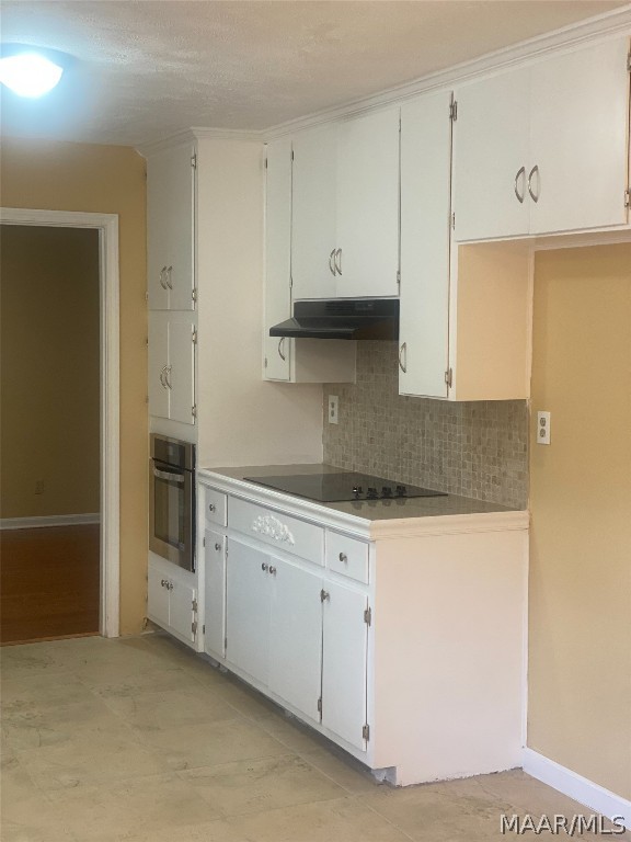 kitchen featuring tasteful backsplash, black electric cooktop, white cabinetry, and stainless steel oven