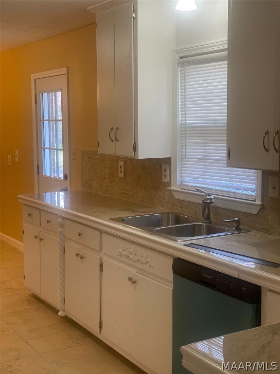 kitchen with stainless steel dishwasher, light tile flooring, white cabinets, backsplash, and sink