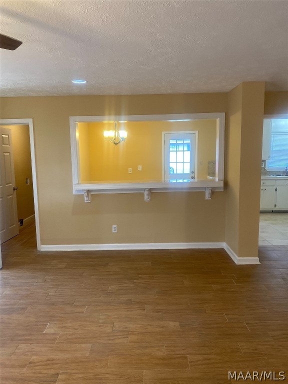 spare room featuring light hardwood / wood-style flooring and a textured ceiling