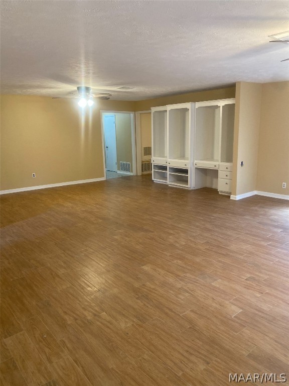 spare room with dark hardwood / wood-style flooring, a textured ceiling, and ceiling fan