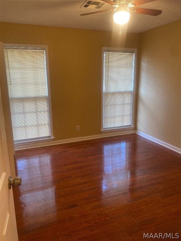 spare room with dark hardwood / wood-style floors and ceiling fan