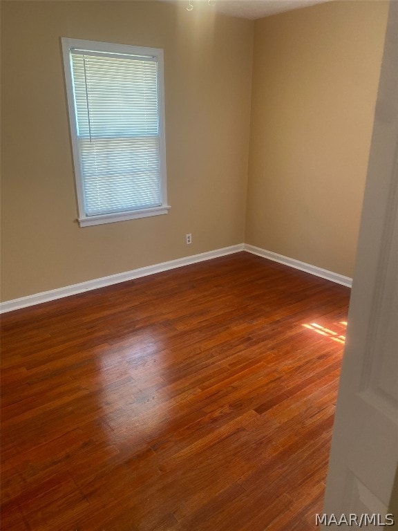 spare room featuring dark wood-type flooring