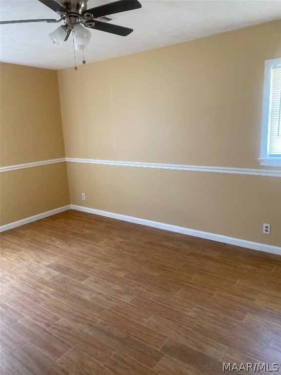 unfurnished room with ceiling fan and dark hardwood / wood-style flooring