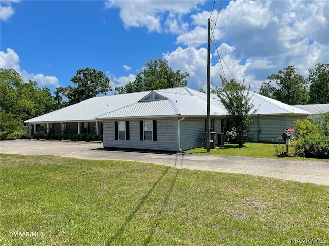 ranch-style house featuring a carport, a front yard, and central air condition unit