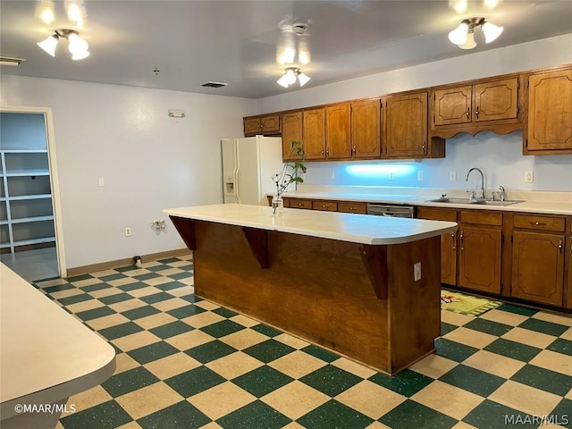 kitchen with white refrigerator with ice dispenser, light tile flooring, sink, stainless steel dishwasher, and a kitchen island