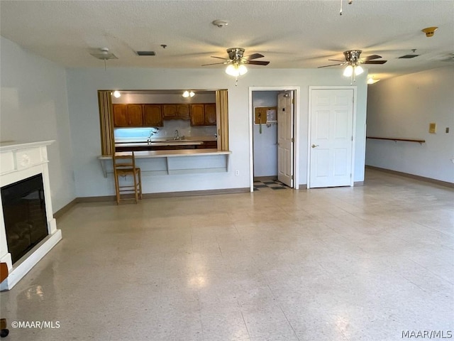 unfurnished living room with light tile floors, a textured ceiling, and ceiling fan