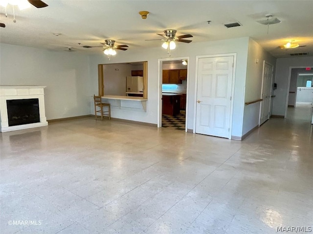 unfurnished living room featuring ceiling fan and light tile floors