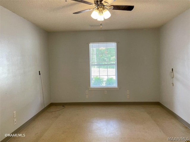 tiled empty room featuring ceiling fan and a textured ceiling