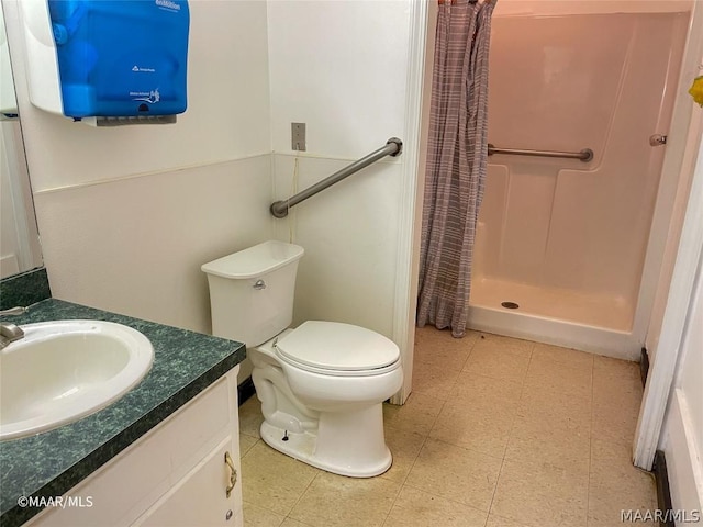 bathroom with curtained shower, tile floors, toilet, and vanity