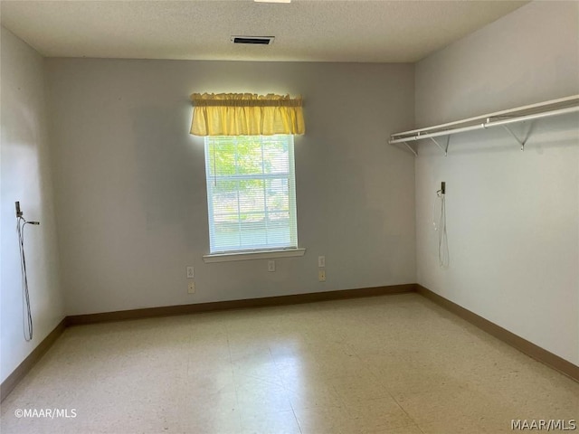 tiled spare room with a textured ceiling