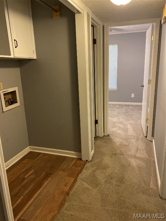 hall featuring a textured ceiling and carpet floors