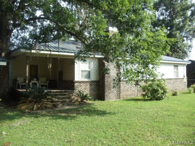 rear view of house featuring a lawn