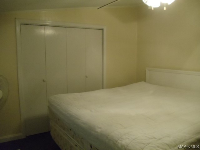 bedroom with ceiling fan, lofted ceiling, and a closet