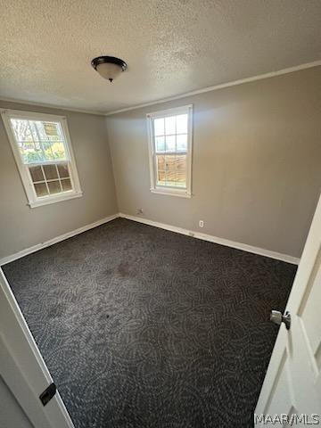 carpeted empty room featuring a textured ceiling