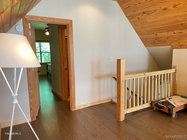 hallway featuring dark hardwood / wood-style floors, wooden ceiling, and lofted ceiling