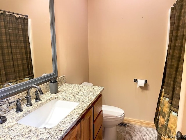 full bath with toilet, baseboards, tile patterned flooring, and vanity