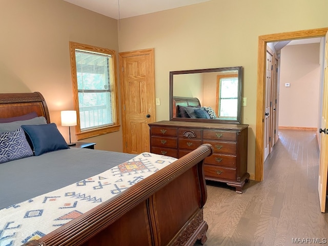 bedroom with multiple windows and light wood-type flooring