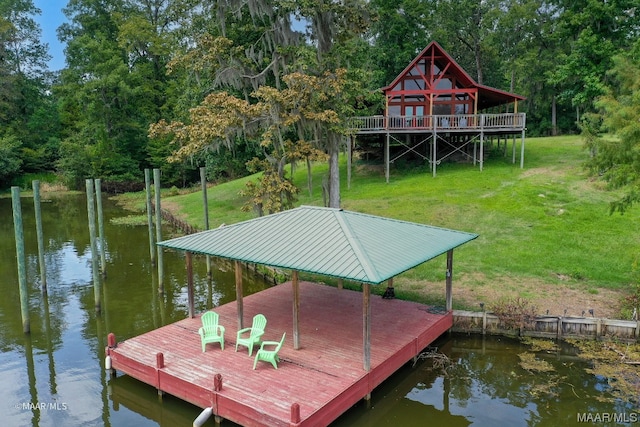 view of dock featuring a deck with water view and a yard