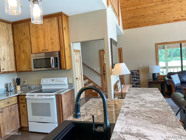 kitchen featuring white range with electric cooktop, decorative light fixtures, vaulted ceiling, and sink