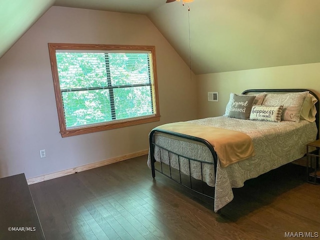 bedroom featuring baseboards, visible vents, wood finished floors, and lofted ceiling