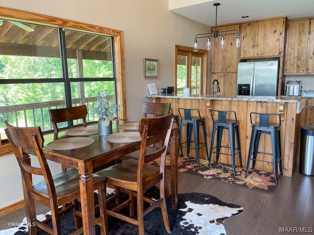 dining area featuring a wealth of natural light, sink, an inviting chandelier, and dark hardwood / wood-style flooring