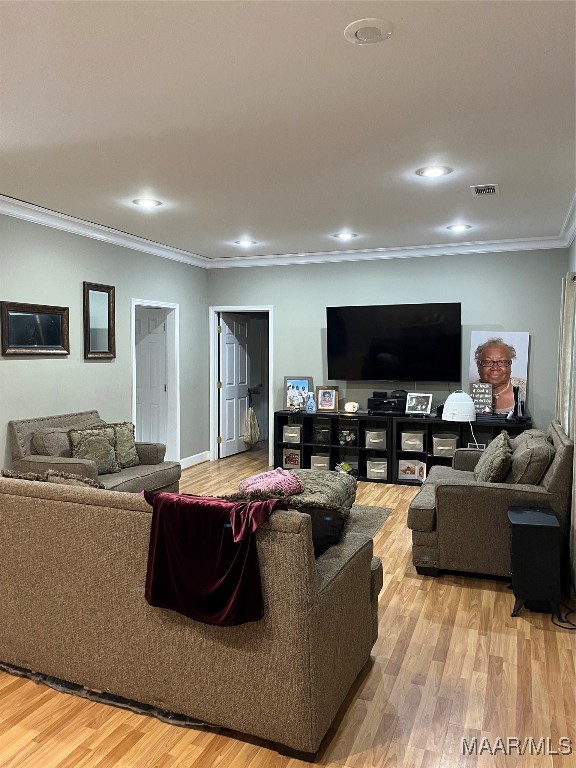 living room featuring light hardwood / wood-style floors and crown molding