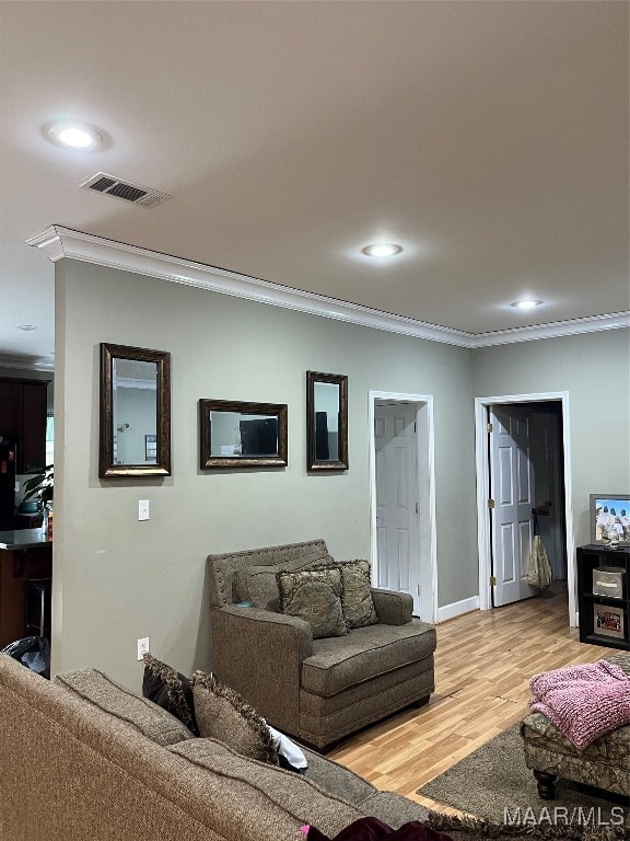 living room featuring light hardwood / wood-style flooring and crown molding